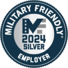 Seal of "MILITARY FRIENDLY 2024 SILVER EMPLOYER" with a central white star, dark and light blue rings, and silver and white text accents.