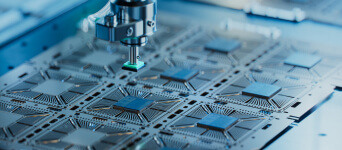 Precision robotic tooling arm interacting with a semiconductor wafer, which contains a grid of square dies with intricate circuitry, in a controlled cleanroom environment.